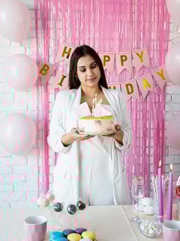 Beautiful woman celebrating birthday party holding a cake photo
