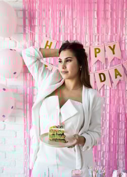 Beautiful woman celebrating birthday party holding a piece of cake making wish photo