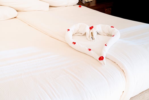 Heart shape made of towels on the bed in hotell room apartment photo