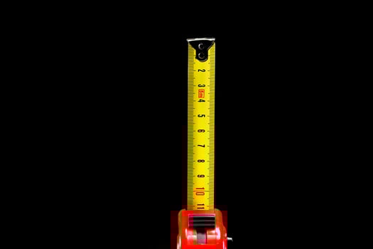 repair and construction concept. red with black construction roulette isolated on a black background close up. front view with copy space for text photo
