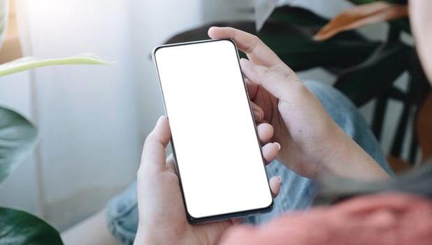 Top view Woman sitting and holding blank screen mock up mobile phone photo