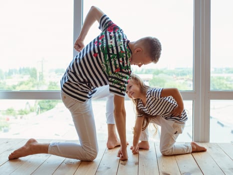 caucasian siblings playing super heroes by the window. Family, relatives, relationship and game concept. photo