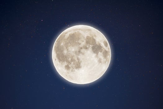 Iridescent glow of full moon in the night starry sky photo