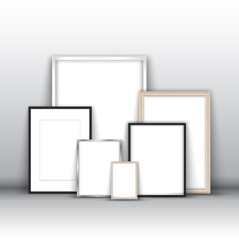 Blank picture frames against a wall vector