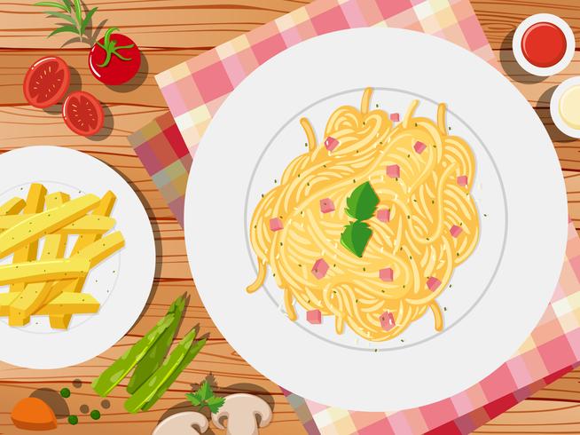 Spaghetti y frenchfries en la mesa vector