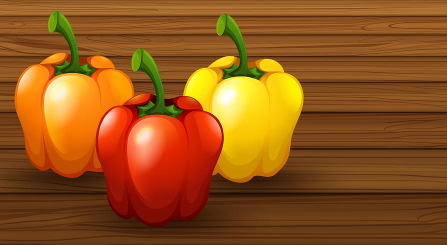 Three Different Bell Pepper on Wooden Background vector