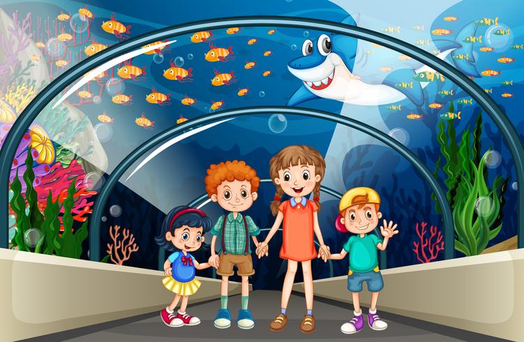 Niños visitando el acuario lleno de peces. vector