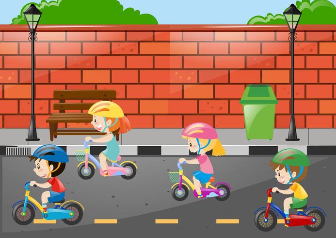 Cuatro niños montando bicicleta en la carretera. vector