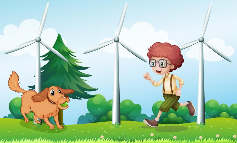 A boy playing with his dog near the windmill vector