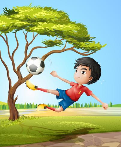 Un niño jugando al fútbol en la carretera. vector