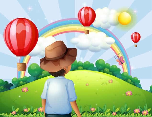 Un niño en la cima de la colina con globos voladores y un arco iris. vector