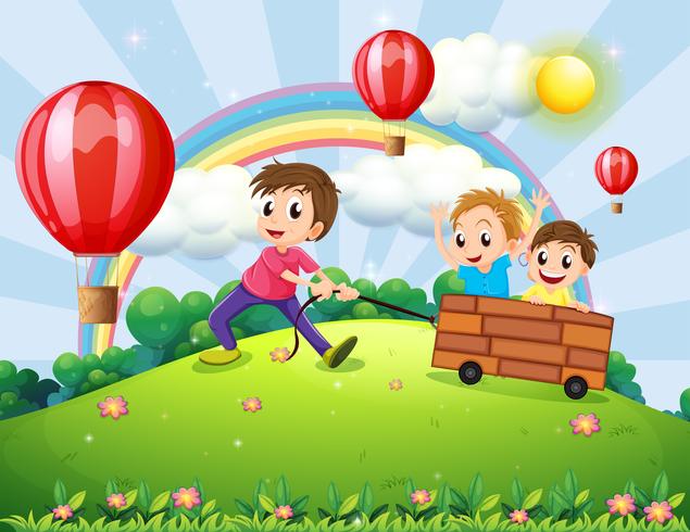 Tres niños jugando en la cima de la colina con un arco iris y globos flotantes vector