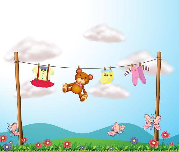 A child's clothes hanging with a teddy bear vector
