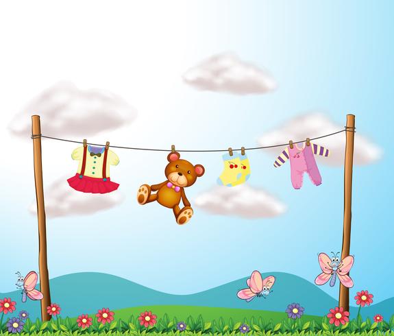 A child\'s clothes hanging with a teddy bear