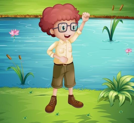 Un chico de aspecto inteligente de pie cerca del río. vector