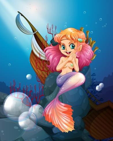 A pretty mermaid under the sea near the rocks vector