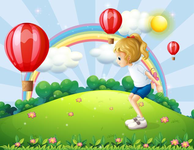 Una niña jugando en la colina con globos flotantes. vector