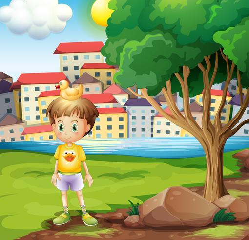 A boy with a rubber duck above his head standing near the tree vector