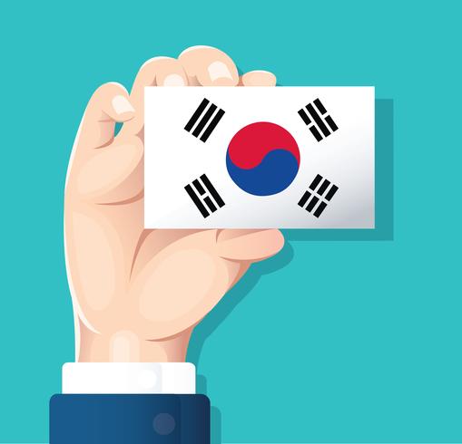 mano que sostiene la tarjeta de bandera de Corea del sur con fondo azul vector