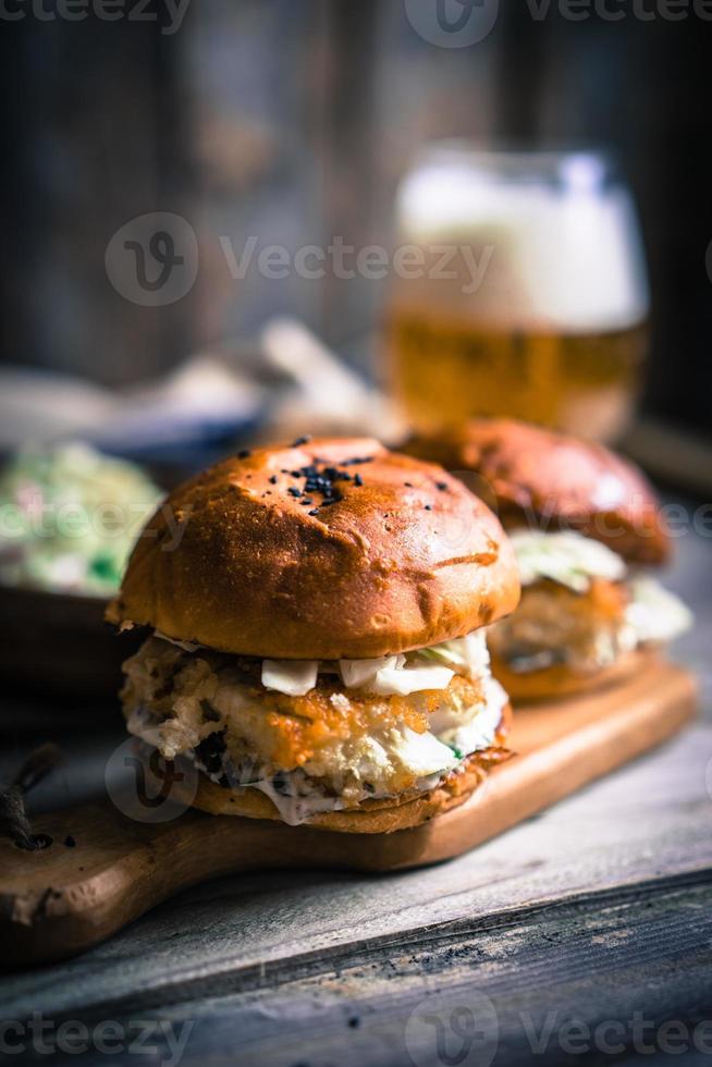 Rustic fish burgers with coleslaw and beer photo