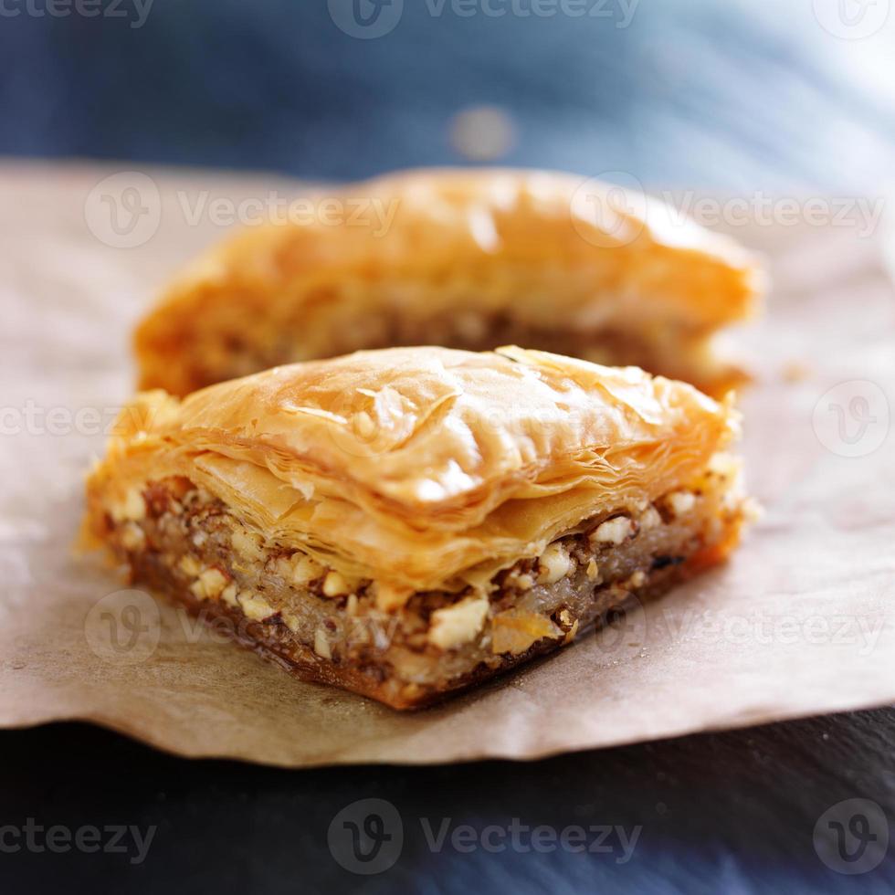 two pieces of baklava on wax paper photo