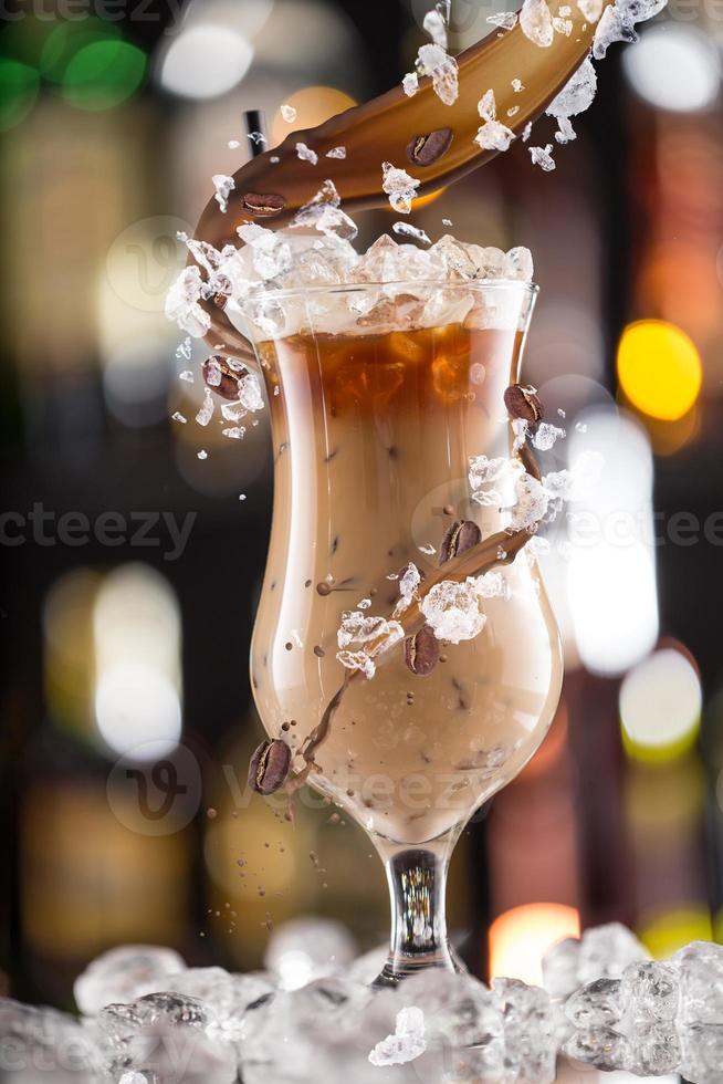 Cold coffee drink with ice, beans and splash photo