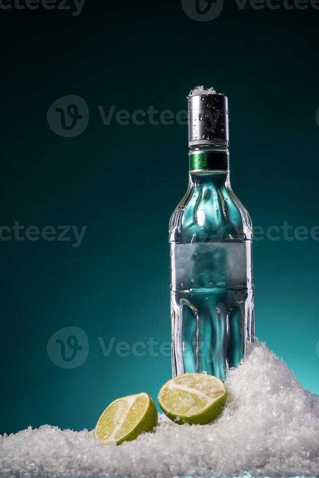 botella de vodka y rodaja de lima foto