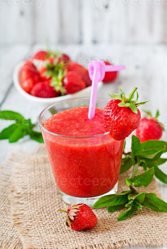 Strawberry smoothie in glass and mint leaves photo