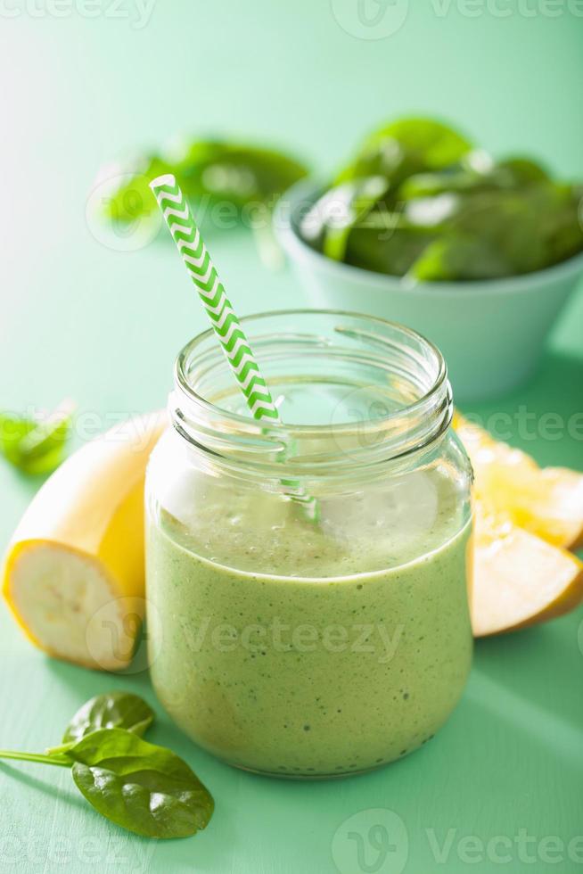 healthy green spinach smoothie with mango banana in glass jar photo