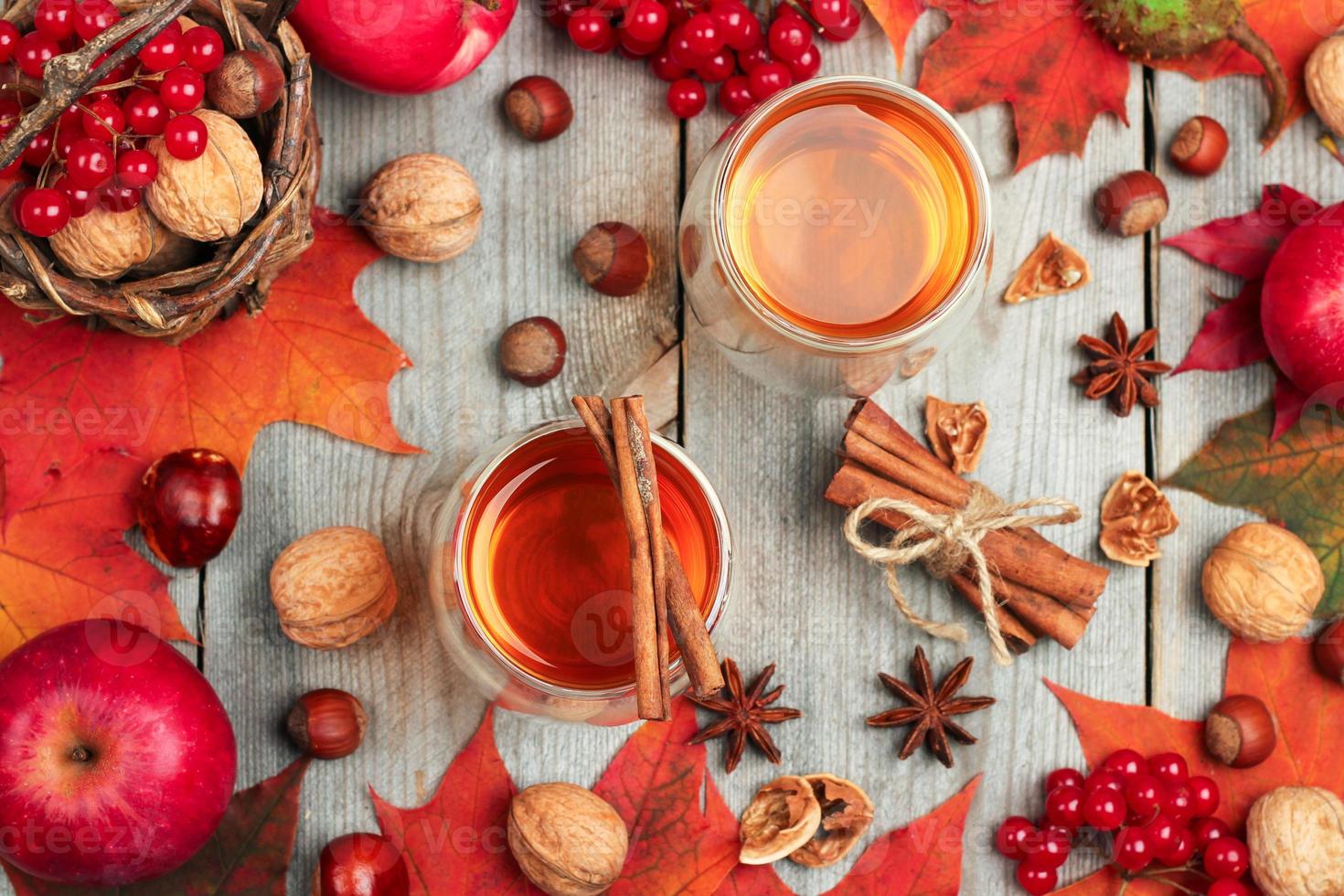 Autumn hot beverage in a glass with fruits and spices photo