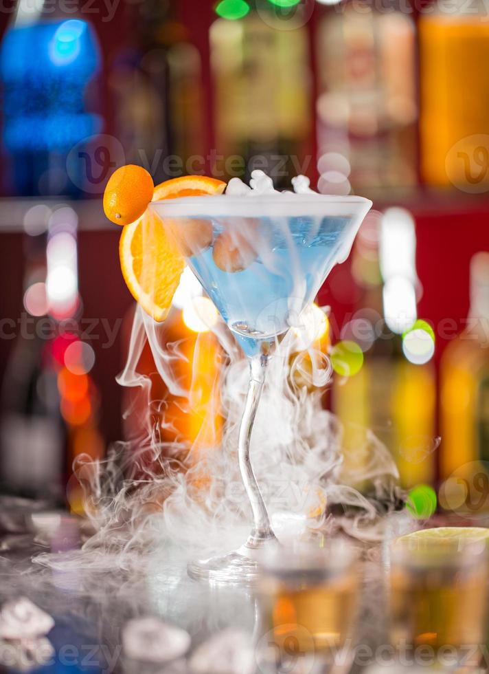 Cocktail with ice vapor on bar desk photo