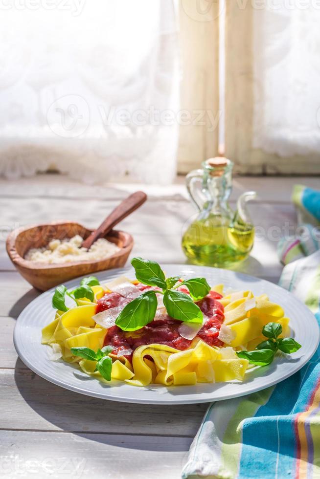 Tasty pappardelle pasta with tomato sauce and basil photo