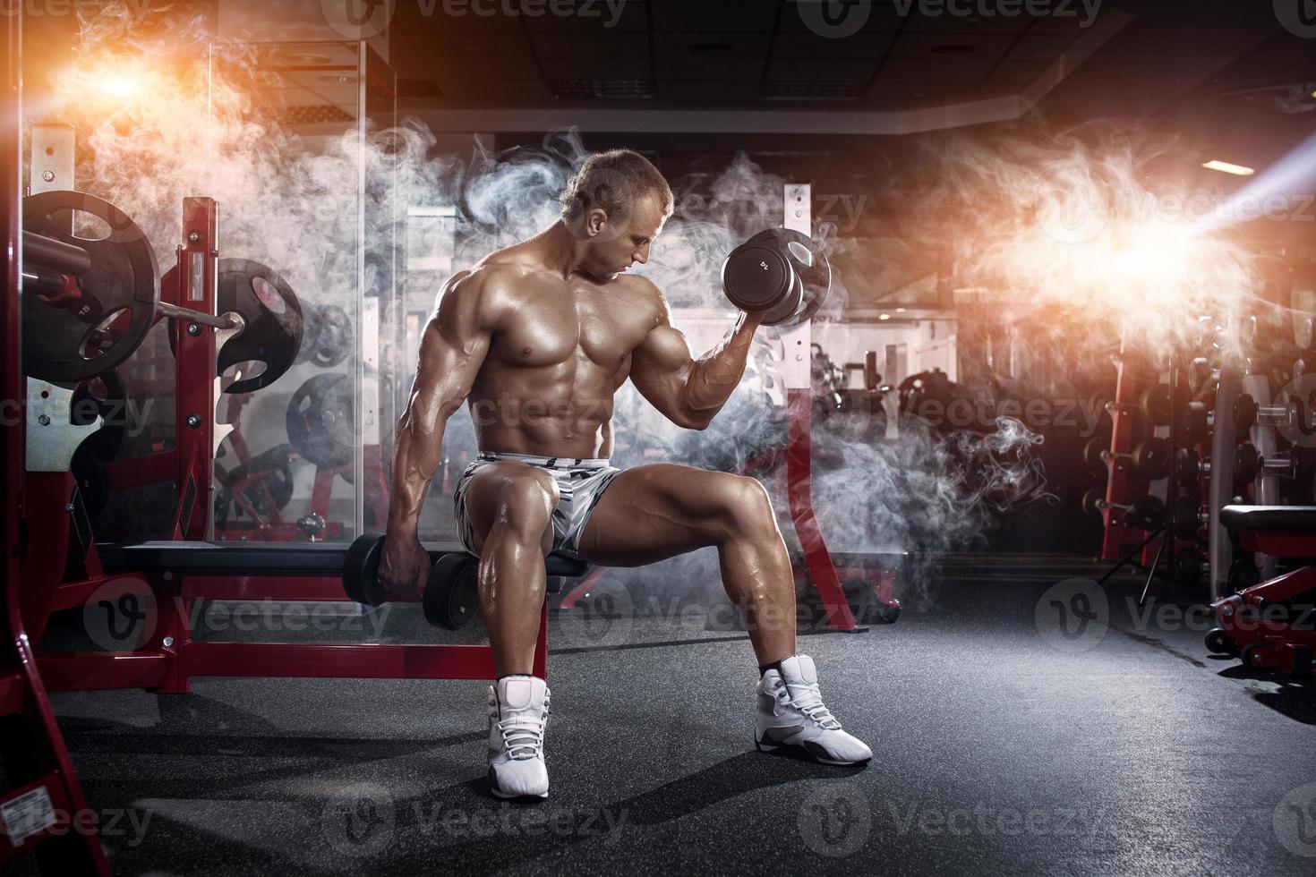 culturista haciendo ejercicio de flexión de bíceps con pesas foto