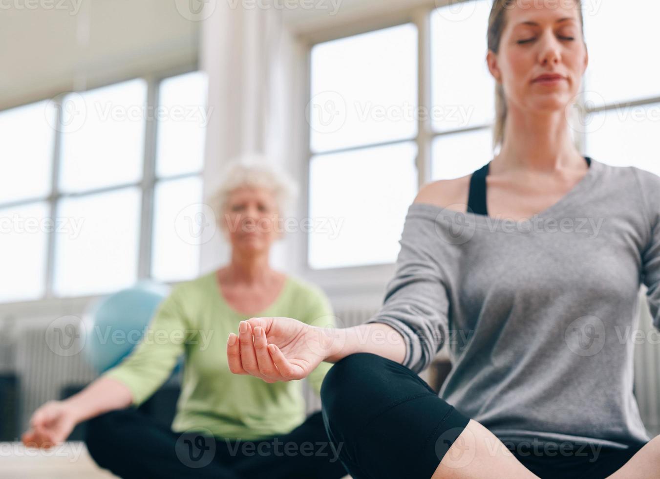 Relaxed fitness women practicing yoga at gym photo