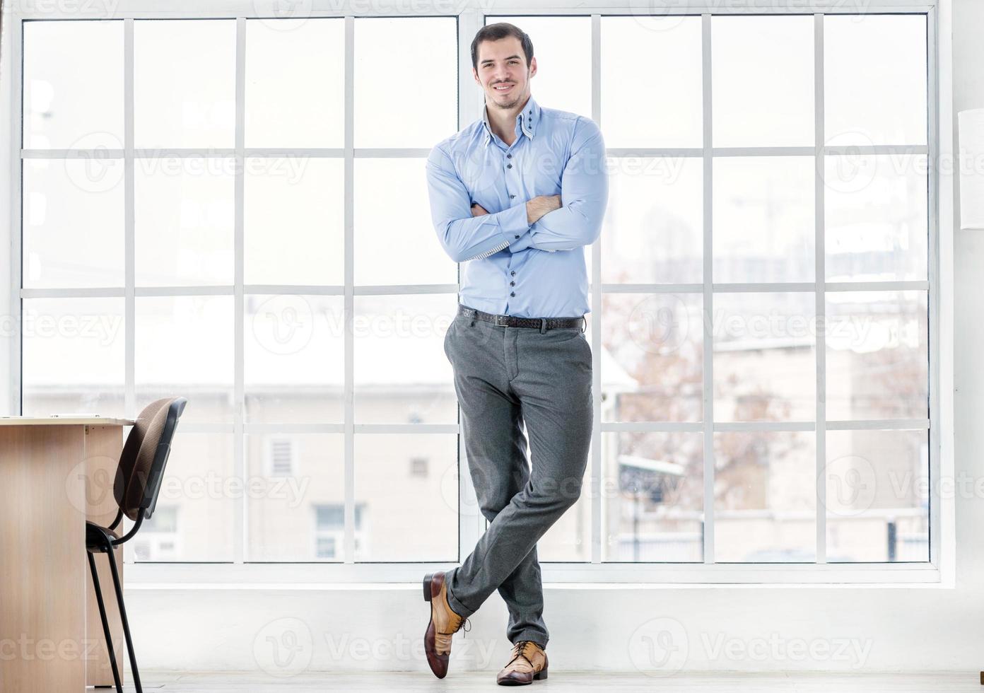 Confident businessman standing in office. Successful businessman photo
