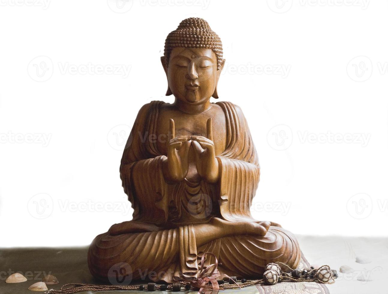 Wooden buddha in meditation isolated in white background photo