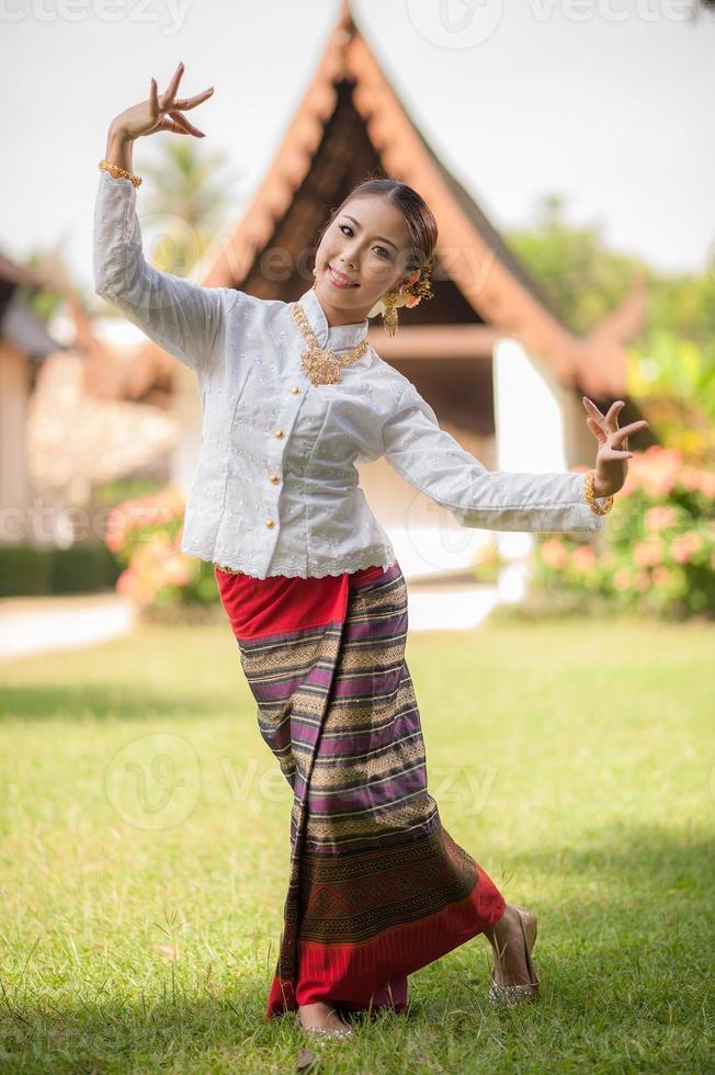 Young woman in traditional garb performing a cultural dance photo
