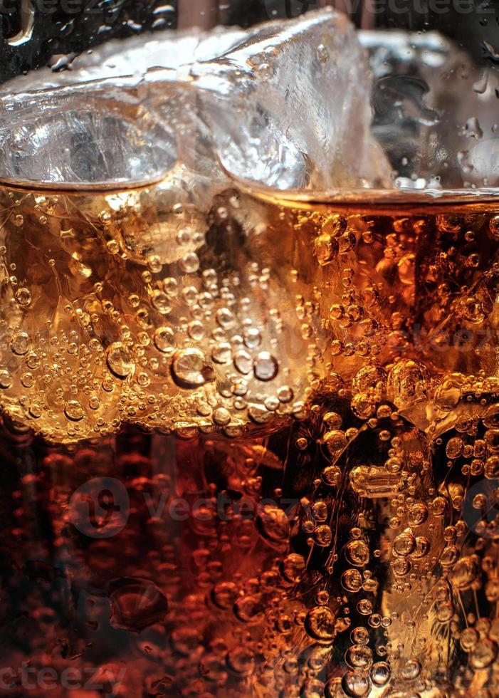 Bubbles in the glass of cola with ice. photo