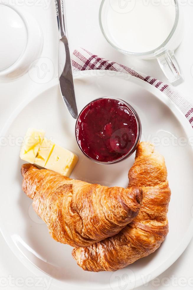 Fresh croissants with butter and a glass of milk photo