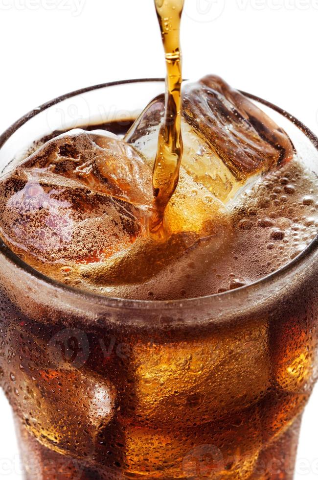 Glass of coke being poured and fizzing photo