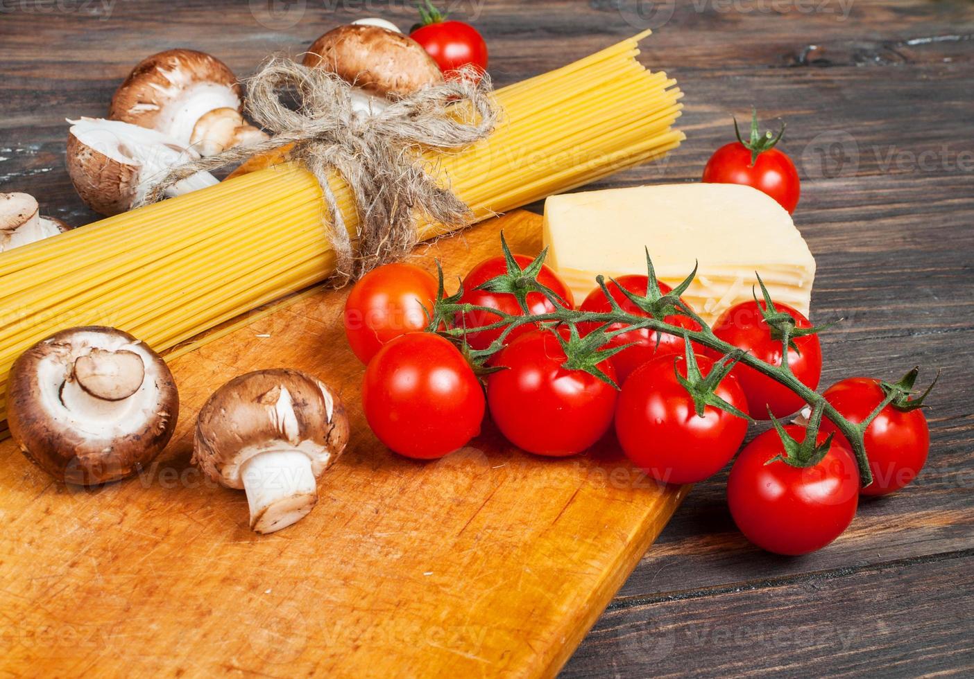 Pasta ingredients - cherry tomatoes, mushrooms,  garlic, broccoli,  cheese on photo