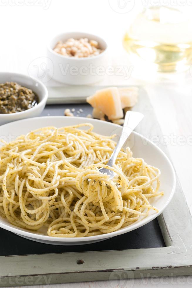 Espaguetis con pesto y queso en un plato, enfoque selectivo foto