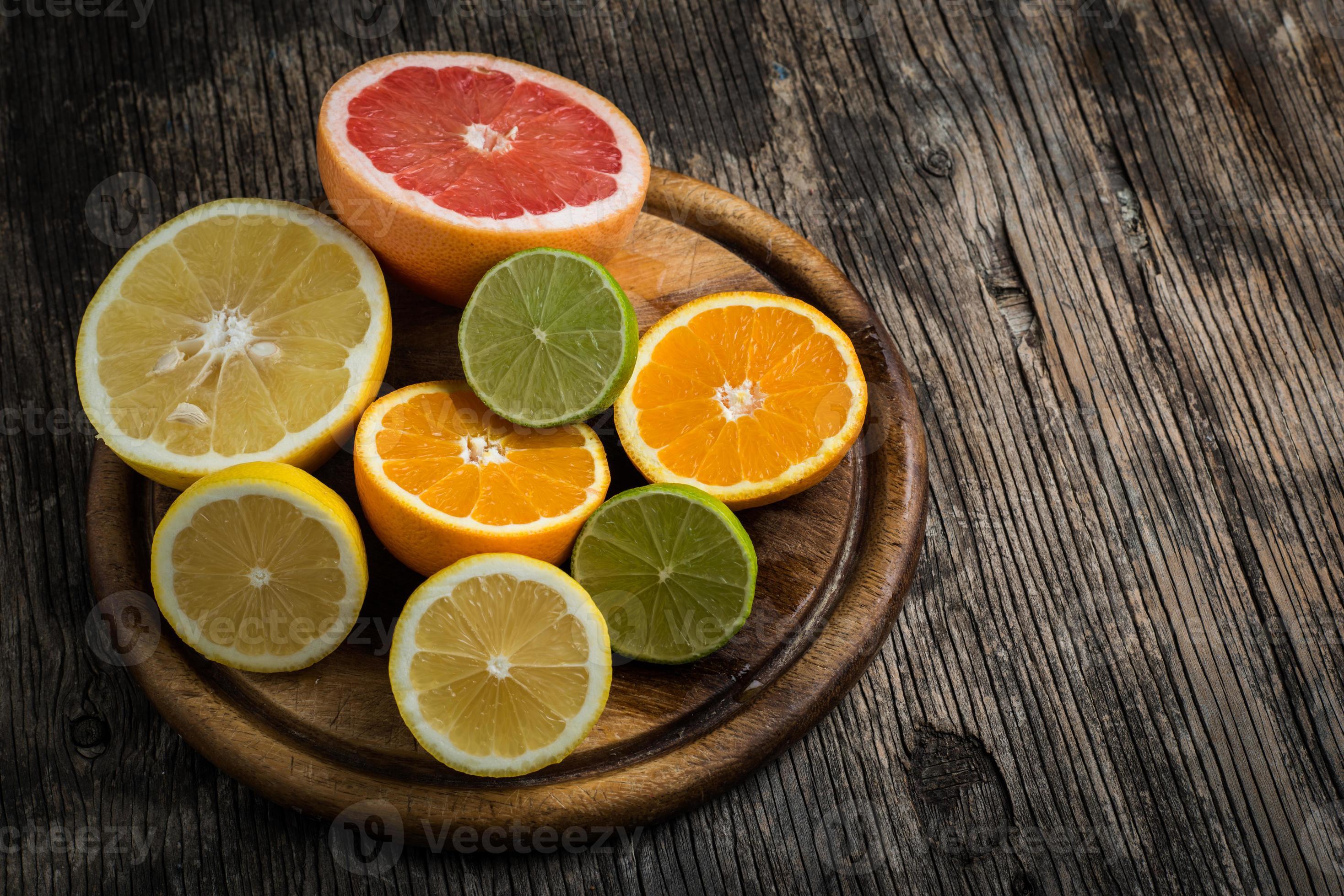 Halves of citrus fruits on wooden background photo