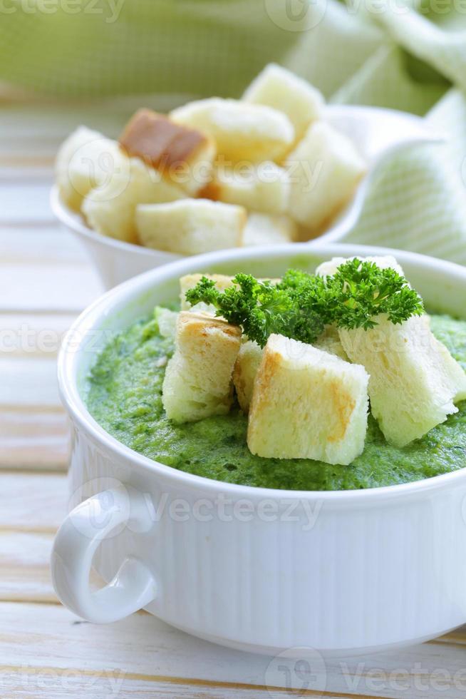 vegetable broccoli cream soup with white croutons and parsley photo