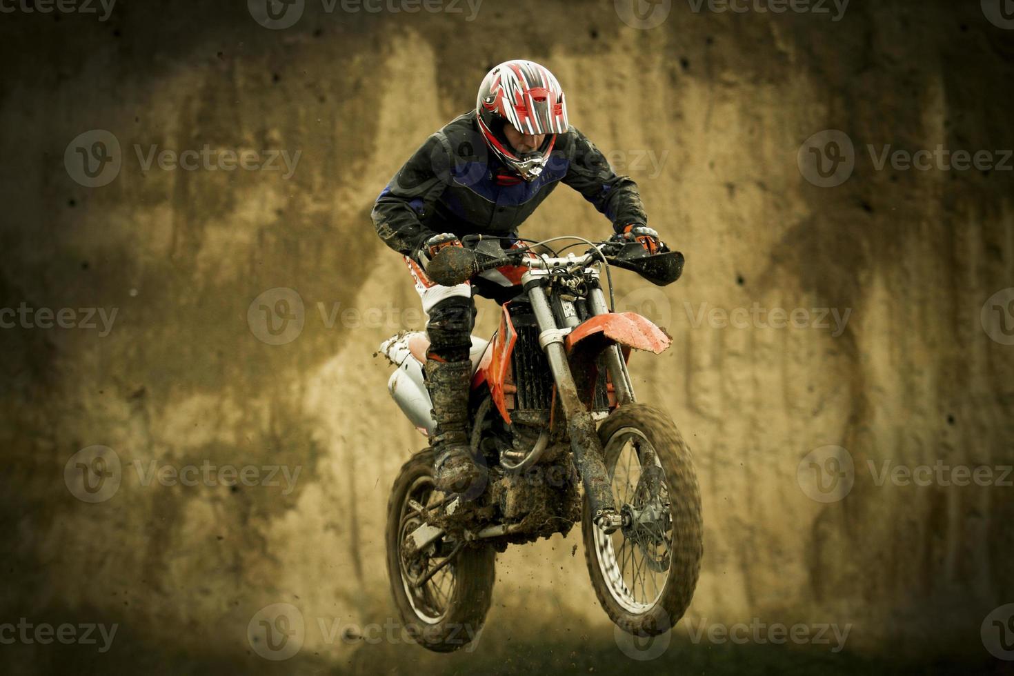 Motocross enduro rider jumping with motorcycle photo