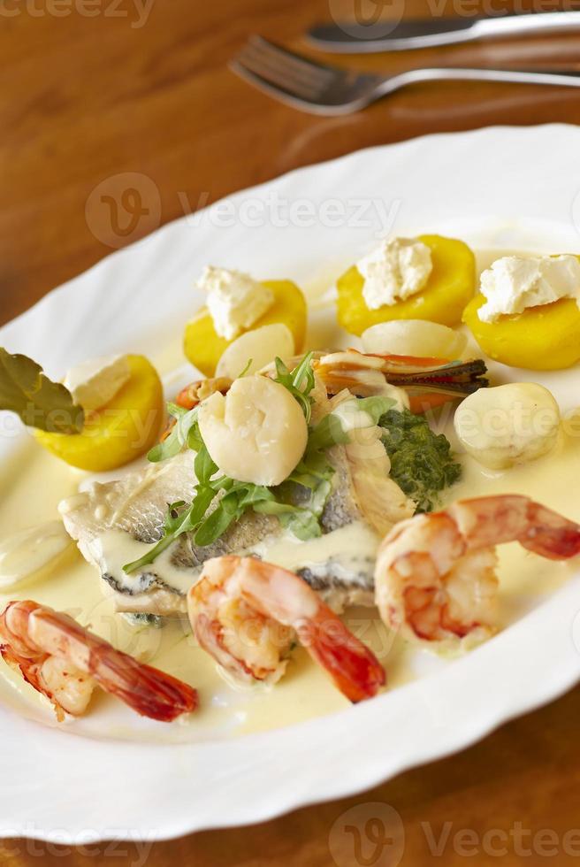 Seafood dish with spinach, potatoes and cream sauce photo