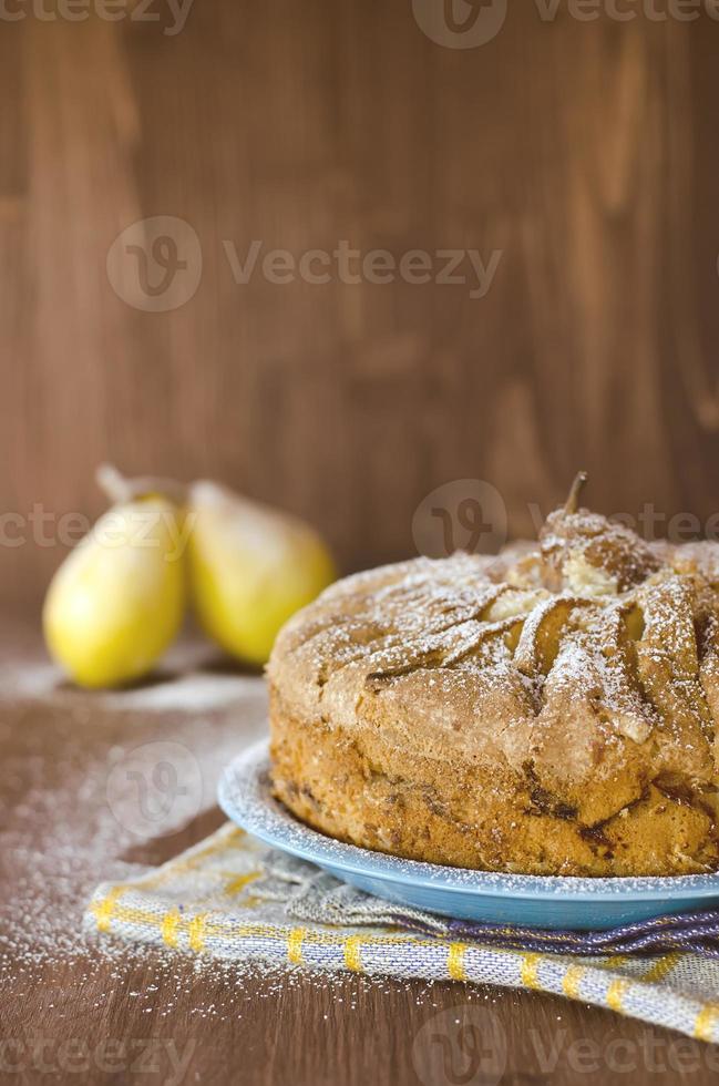 Pear pie with pears on the wooden background photo