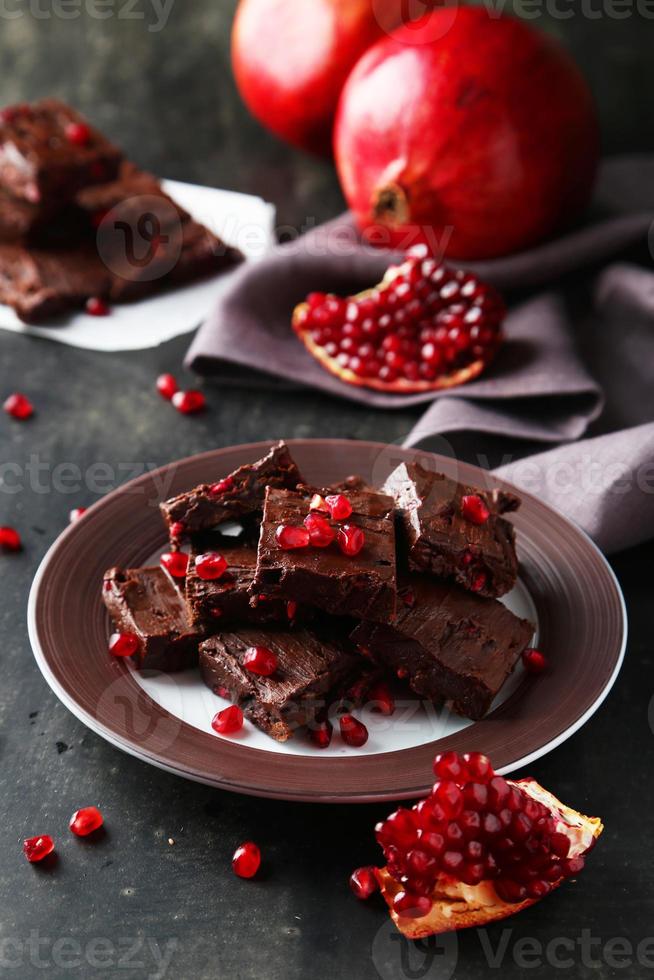 Homemade chocolate fudge with pomegranate on plate photo