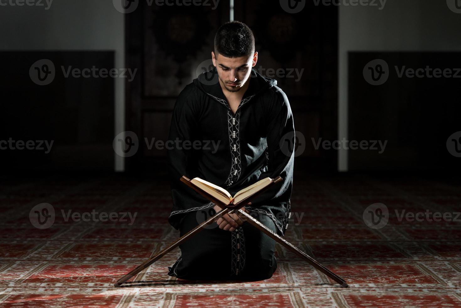 joven musulmán leyendo el Corán foto