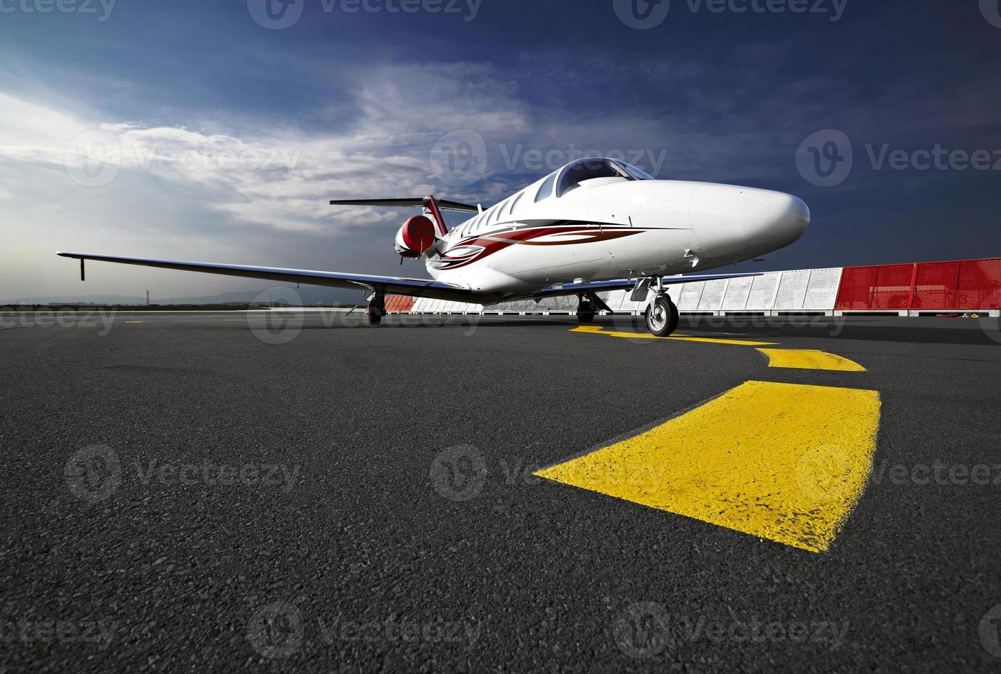 A small business jet on a runway from a ground view photo